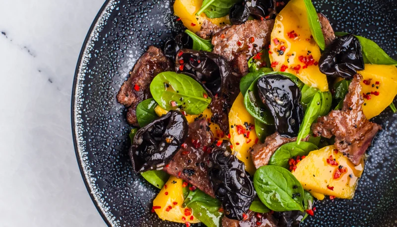 Carne de buey con mango y espinacas