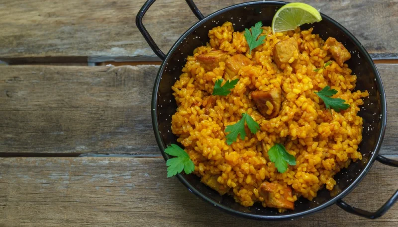 Paella de conejo, pollo y boletus